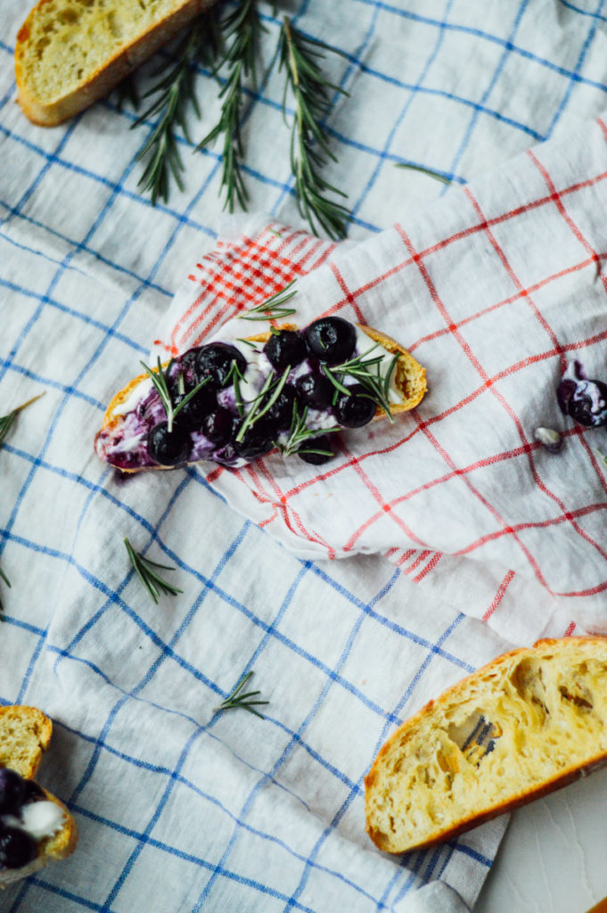 A deliciously easy Fourth of July Crostini recipe with roasted blueberries, whipped ricotta, honey, and rosemary / bygabriella.co @gabivalladares