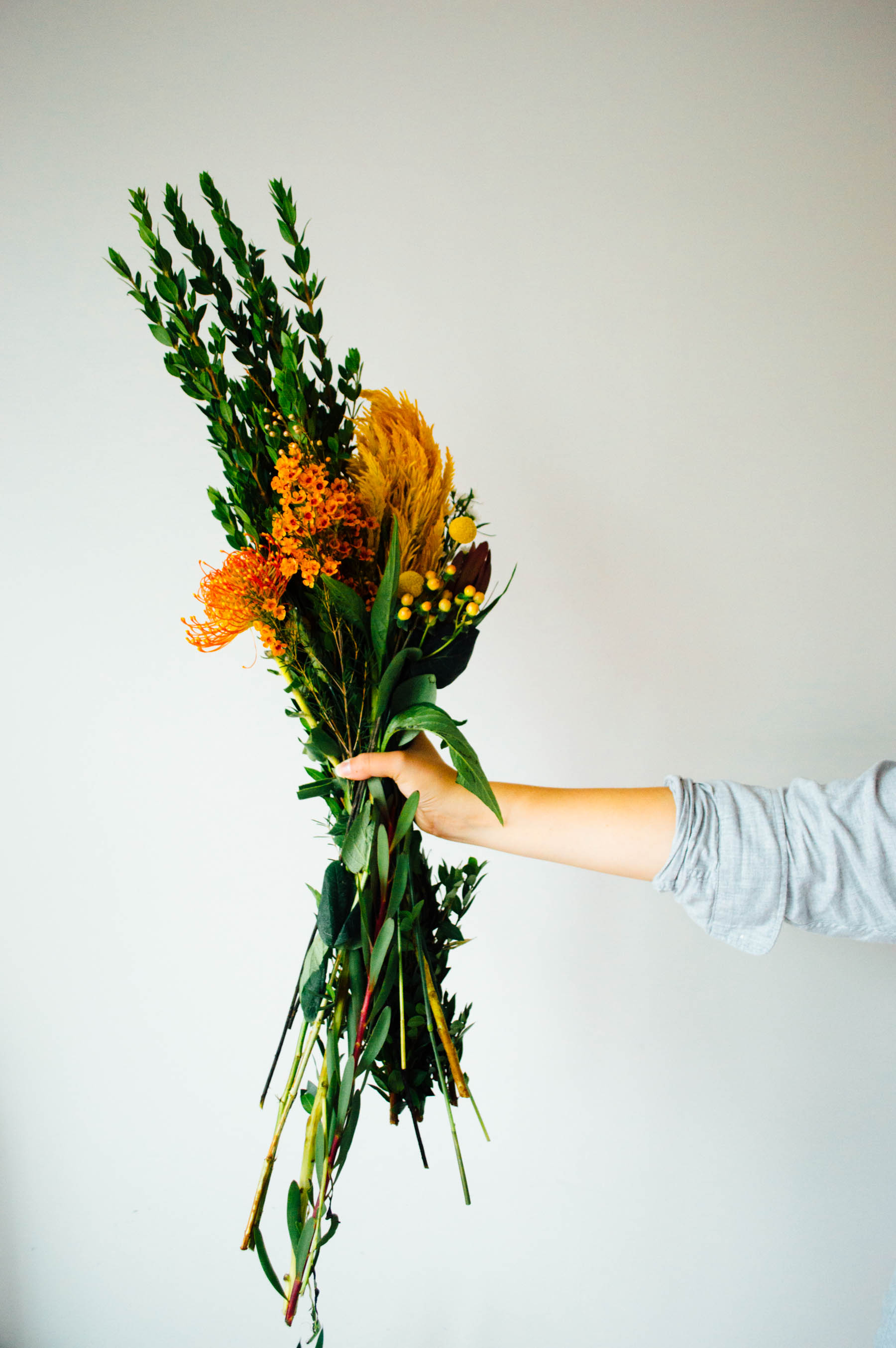 A stunning autumn-inspired floral arrangement with lush greens, bright yellows, and rich oranges | bygabriella.co