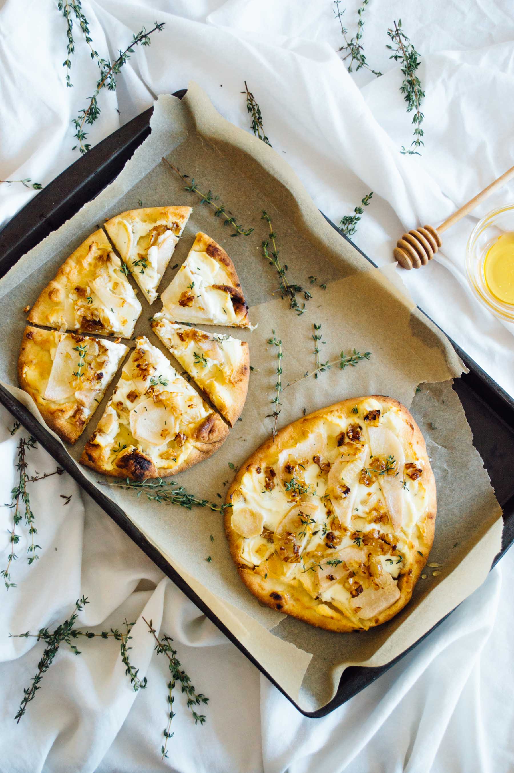 Pear Naan Pizza recipe with Honey Whipped Goat Cheese, fresh thyme and a honey drizzle. | bygabriella.co